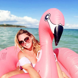 Nickie Harris, senior travel designer at Romantics Travel, relaxing on a flamingo float in the ocean