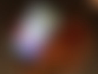 Smartphone mit geöffneter Social-Media-App auf einem Holztisch, daneben ein Glas mit Tee und ein schwarzes Armband. Das Bild spiegelt die Verbindung zwischen Technologie und täglichen Gewohnheiten wider, insbesondere die Nutzung von Social Media und die Ablenkung, die sie verursachen kann.