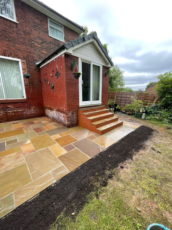 a small extension with sandstone flags and a small step into the main house