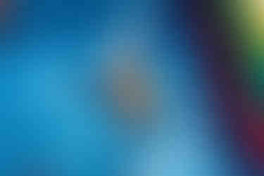 Young girl smiling as he slides down and exits a colorful inflatable slide.