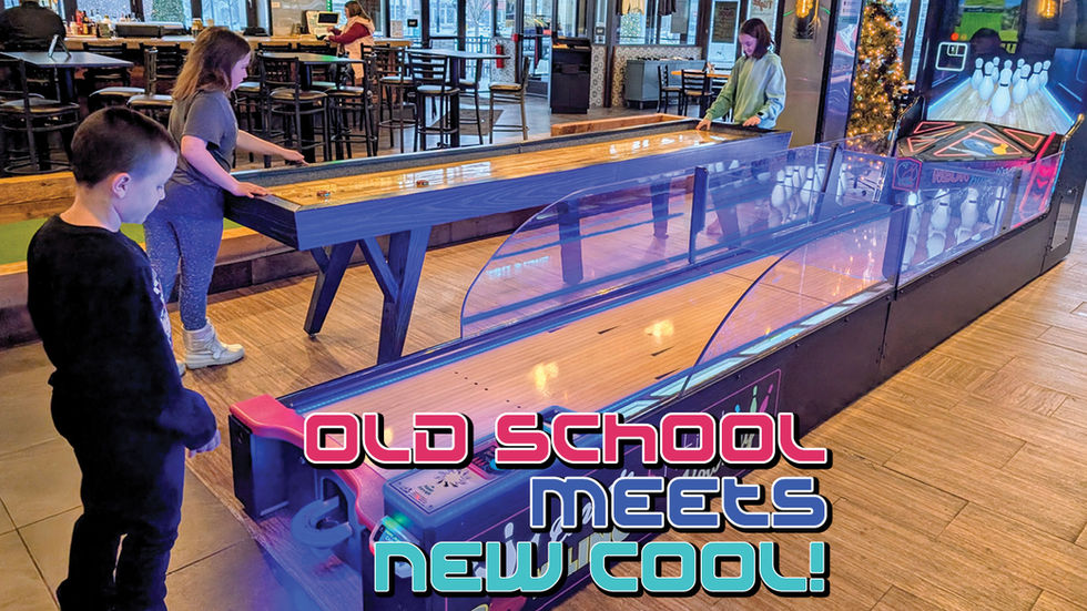 Inside Baxter’s R•Cade in Southpointe, two children stand at a "Classic Neon Bowling" arcade game in the foreground. In the background, another child plays on a long wooden shuffleboard table within the modern, well-lit entertainment venue and restaurant space.