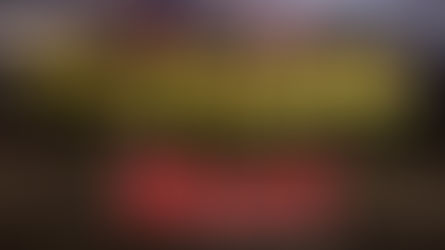 A group of approximately 20 firefighters from the Fuller Hose Volunteer Fire Department posing in full turnout gear and high-visibility vests. They are positioned in front of two gray fire trucks with their emergency lights flashing under a dramatic, cloudy twilight sky. Several firefighters in the front row are kneeling and holding hydraulic rescue tools.