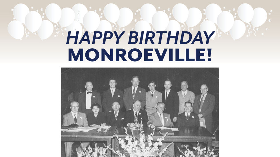 A celebratory graphic with a cream to light grey gradient background. At the top, there is a decorative border of various white balloons with strings. Centered below the balloons is the text "HAPPY BIRTHDAY MONROEVILLE!" in bold, dark blue capital letters, arranged on two lines. Below the text is a faded, black and white group photograph showing 13 people, mostly men in suits and one woman, seated and standing behind a long table with large floral arrangements.
