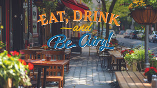 A vibrant and inviting street-side outdoor dining scene on a sunny day. In the foreground, a wooden table and chairs are positioned on a light-colored paved sidewalk, with a planter of red flowers in the corner. Above the seating area, the image features large, stylized text that reads "EAT, DRINK —and Be Airy!" in bold orange and blue lettering. The background shows a perspective view of additional outdoor tables and chairs lining the sidewalk under red awnings, decorated with lush hanging flower baskets filled with yellow and orange blooms.