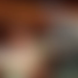 Dorothy Gale and Professor Marvel share a scene on stage, both gazing into a glowing crystal ball positioned between them. Dorothy, wearing her blue gingham dress, sits and holds the prop with both hands. Professor Marvel, wearing his gray suit and a new dark turban, stands over her and gestures toward the crystal ball with both hands.