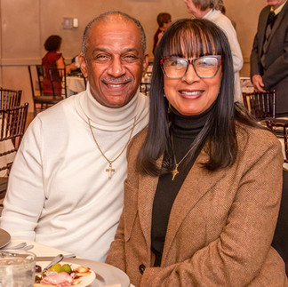 A smiling man and woman sitting together at a dinner table during the 17th Annual Symphony of Food at Bella Sera.