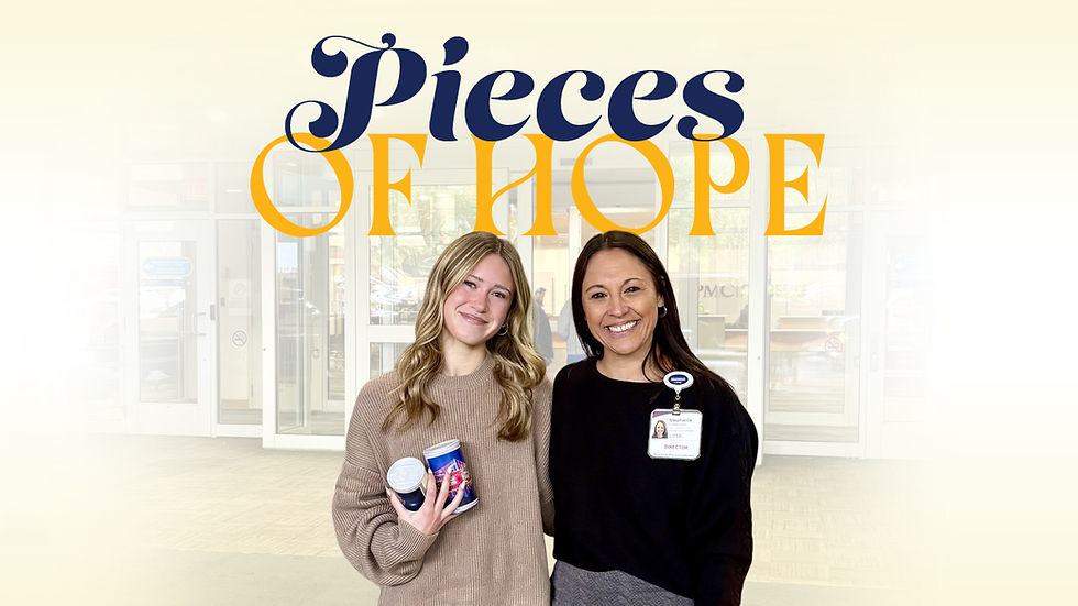 A header image with a dark blue and gold serif font on a light background. Large, bold dark blue text on the top line reads: Pieces. The line below has large, bold gold text that reads: OF HOPE. A photo is superimposed over the lower portion. It shows two smiling women standing on a patio with tiled pavers, in front of glass doors that lead into a modern building. A woman on the left with blonde, wavy, shoulder-length hair wears a light brown knit sweater. She holds two cans of "Puzzles for Patients," featuring colorful nighttime cityscape views. A woman on the right with straight, dark, shoulder-length hair wears a black long-sleeved shirt and grey pants. She wears an ID badge on her right collar, which reads: Stephanie, LSW, DIRECTOR.