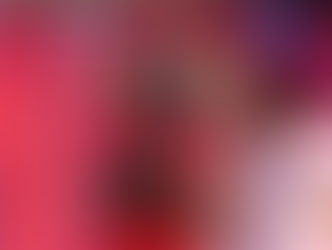 A young actress in a red military-style jacket with gold epaulettes stands center stage with her hands clasped in a pleading gesture, looking upward with an emotional expression. To her right, another actress in a pink dress and a floral headpiece places a supportive hand on her shoulder.