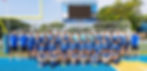 The Camon-McMillan High School boys' soccer team and their coaches pose for a team photo on a turf field in front of a soccer goal and scoreboard.