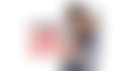 An action shot of Maya Bhandari in a red and black wrestling singlet and headgear, engaged in a competitive match. She is being held from behind by an opponent in a blue singlet as they both grapple for position on a grey wrestling mat. To the left, the stylized article title "Going to the MAT" is overlaid in bold blue and red text.