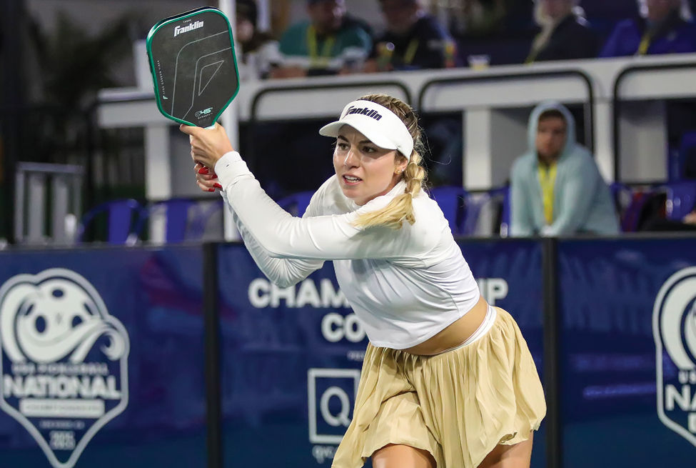 Professional pickleball player Sofia Sewing, wearing a white top and visor and a tan skirt, hits a backhand drive shot during the Pro Women's Singles finals match against Katerina Stewart.