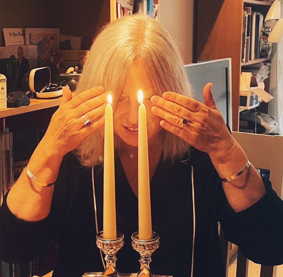 Julia with palms covering her closed eyes while performing hadlakat nerot, the traditional Shabbat candle lighting.