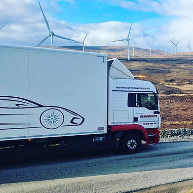 Lorry parked in front of a wind farm