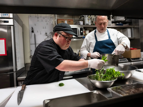 A young chef with autism preparing food in a professional kitchen