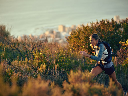woman running on trail, working hard.