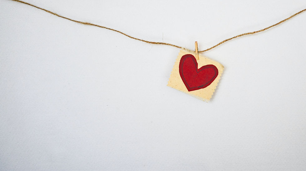 White envelope with red paper heart hanging from gold string