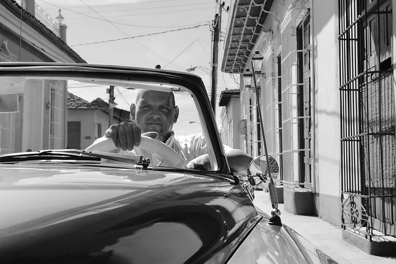Man driving a vintage car through the streets of Trinidad, Cuba