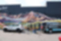 Mobile detailing services cleaning car by mountain mural