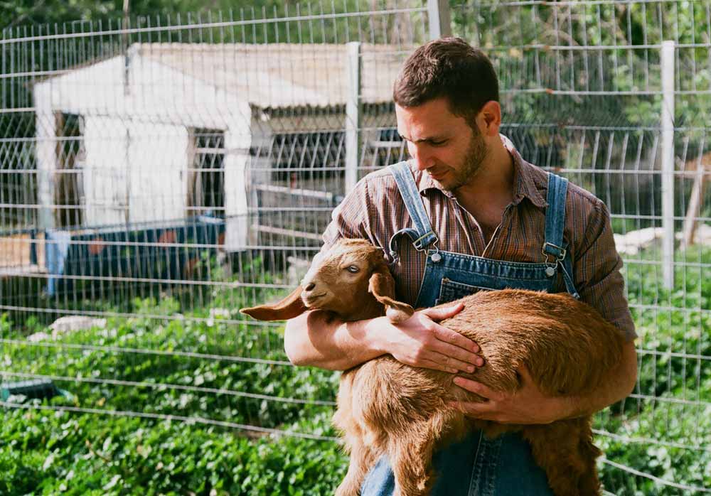 Farmer Holding Goat 