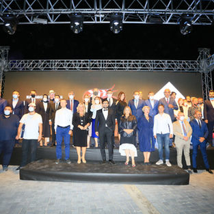 Large group of people standing on stage at an event.