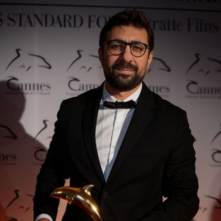 Man in a tuxedo holding a Cannes award - Fuad Guliyev