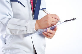 バインダーを持った作業着の人