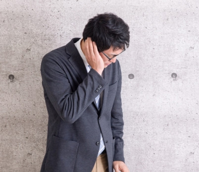 耳をおさえている男性