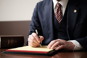 紙に記入している弁護士