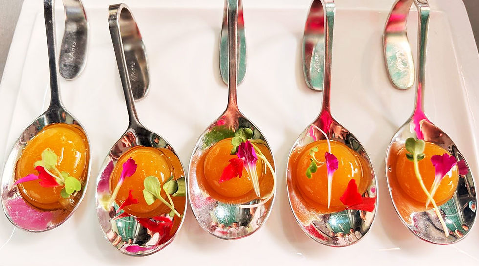 Five spoons hold mango spheres with microgreens and pink petals, arranged on a white tray, creating a colorful, elegant display. Prepared during Molecular Gastronomy Mastrclass 2026 by Chef Nepal