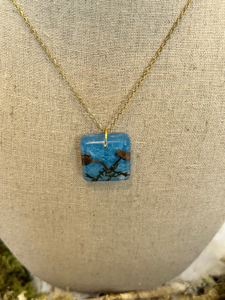 Thumbnail: Front view of blue square necklace encased with real mushrooms and moss
