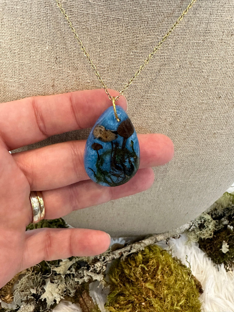 Thumbnail: Front view of blue tear drop necklace encased with real mushrooms and moss