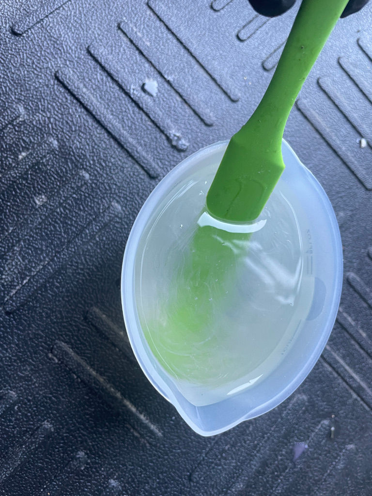 a mixing cup full of unmixed part a and part b epoxy resin which is cloudy and not clear or translucent