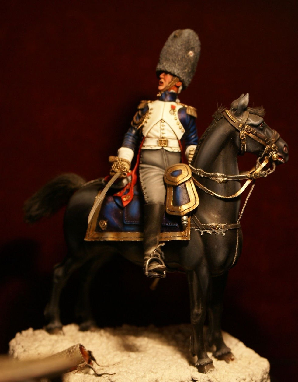 A detailed miniature depicting Louis Lepic leading a cavalry charge at the Battle of Eylau, showcasing his distinctive uniform and commanding presence on horseback.