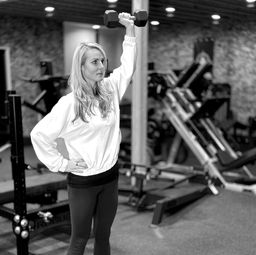 Jessica lifting weights during strength training session in gym
