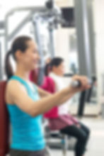 トレーニングマシンで筋トレしている女性