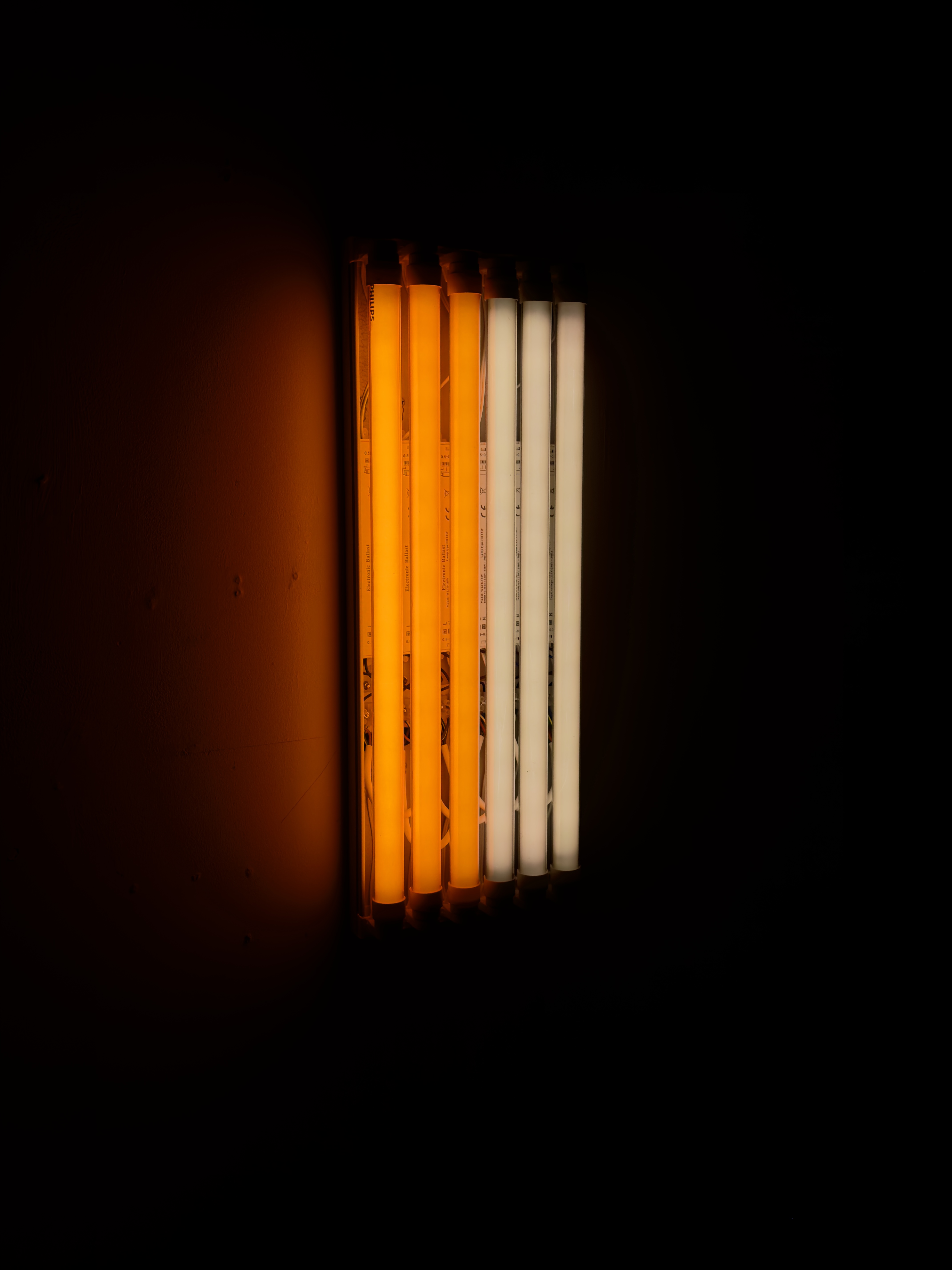 Canto VIII (2026), fluorescent light work by Samuel Harriman using parallel tubes and orange and brown coloured filters