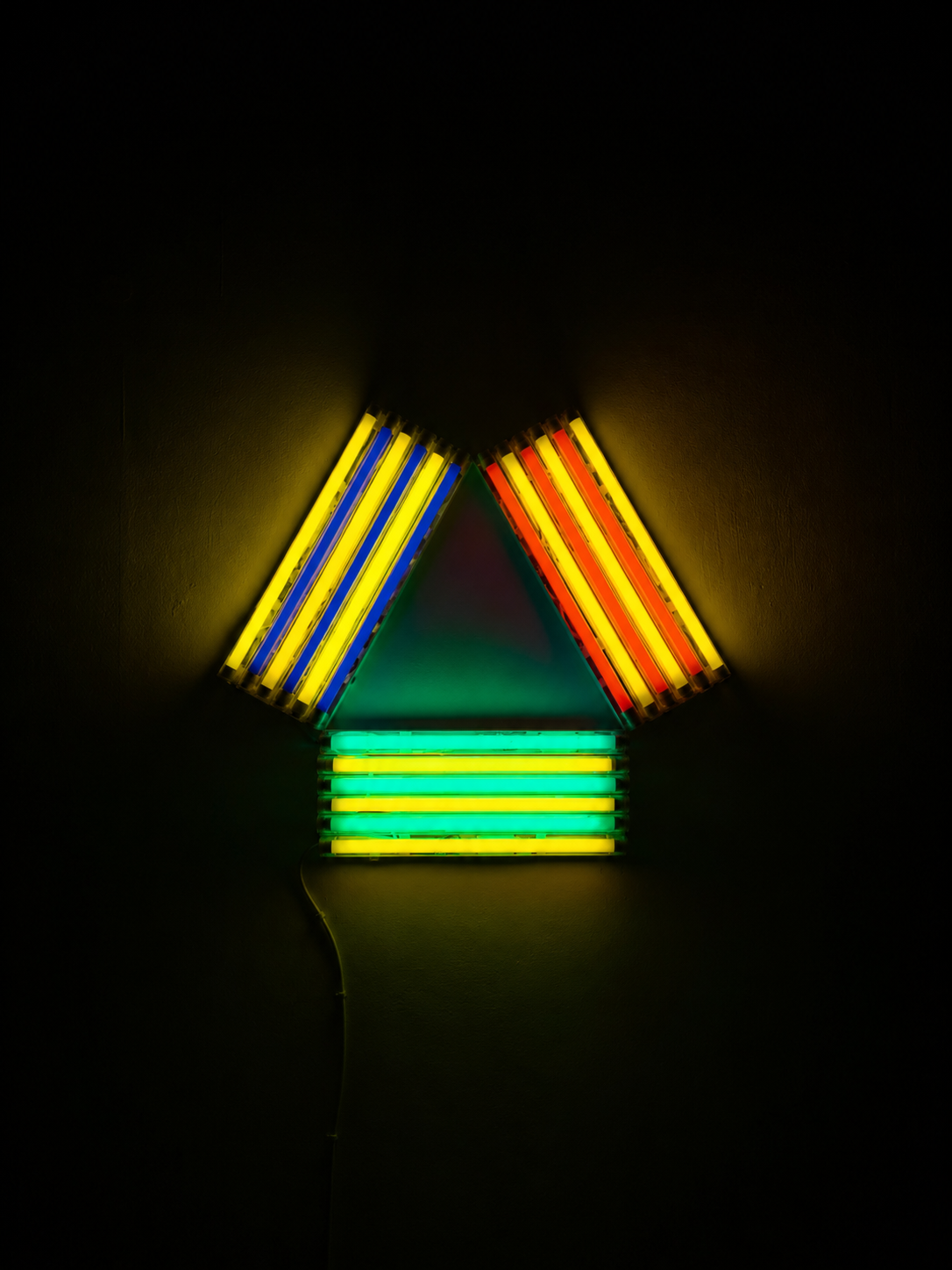 A fluorescent light installation of blue, yellow, red and green alternating lines