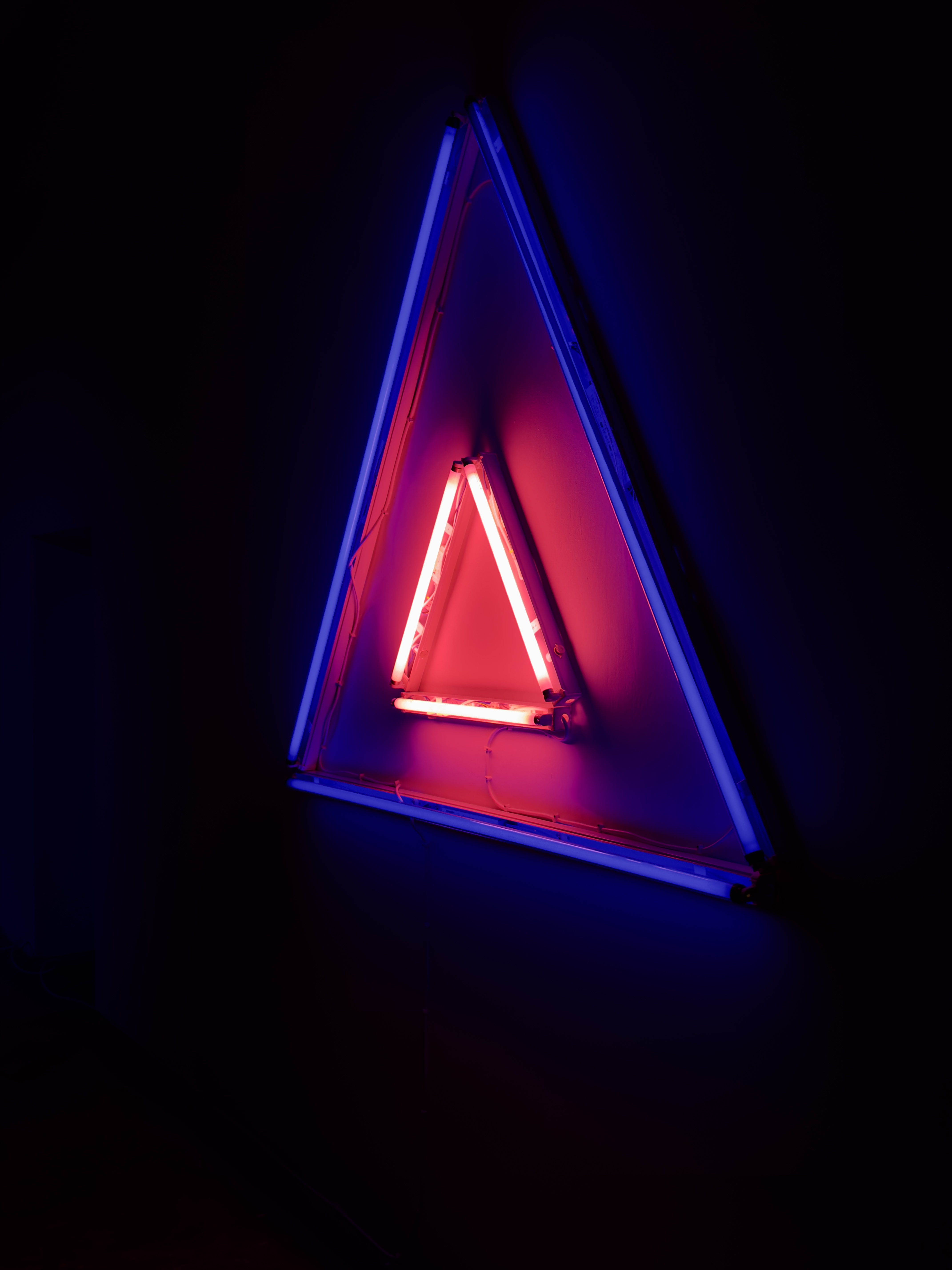 Madonna and Child II, a large blue fluorescent triangle, with a small red fluorescent triangle nested inside of it