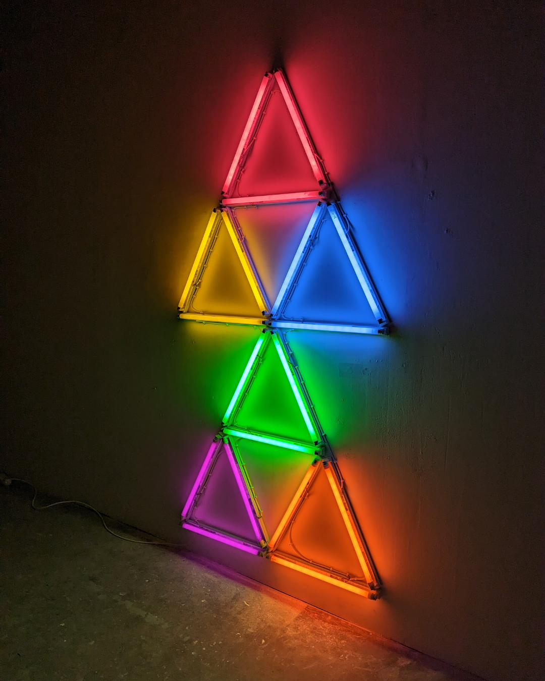 A large fluorescent installation of multicoloured triangles