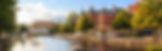 Utsikt över en fridfull å i sverige, en hotellbyggnad syns bredvid