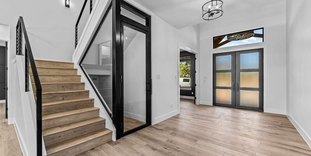 Custom steel stair railing and glass doors in a finished luxury home in Central Texas by JT Metalworks