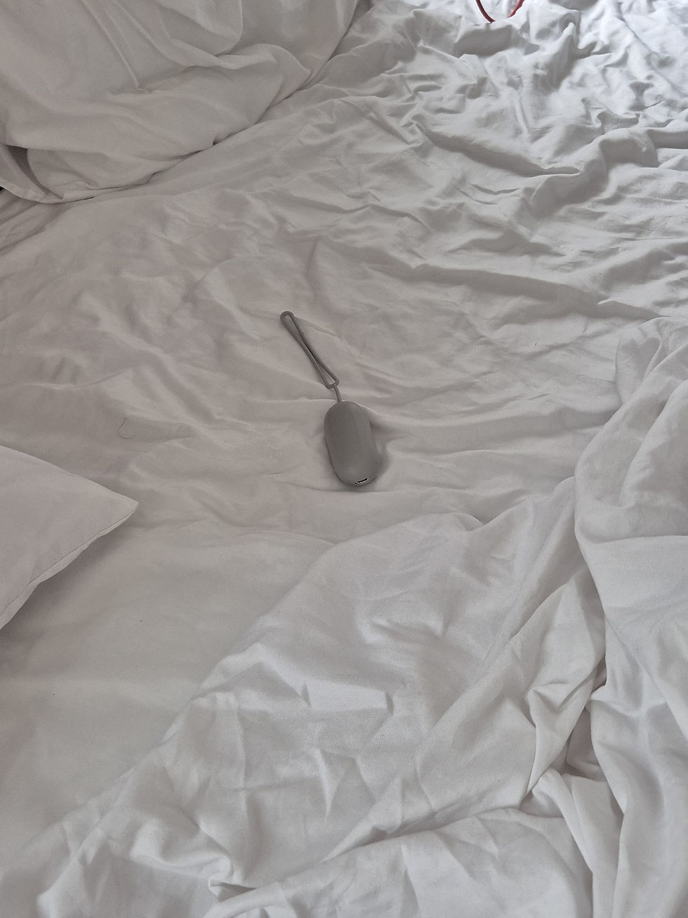 A CalmCarry device laying in a bed.