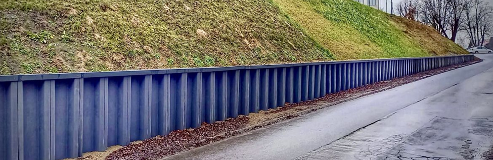 Roadside retaining wall constructed with vertical sheet piles, demonstrating ESC USA‑made vinyl piles