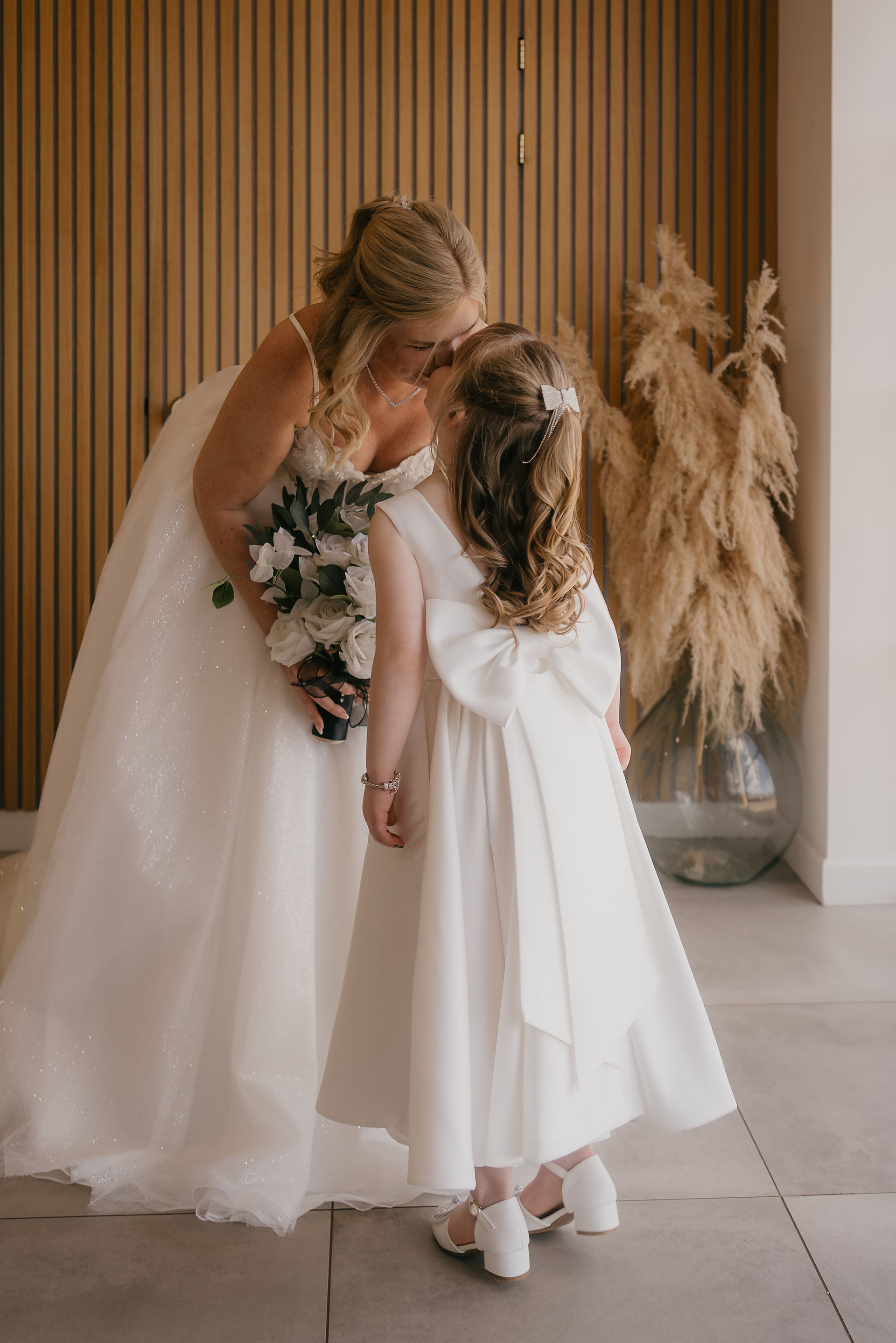bride kissing daughter on her wedding day at upton barn devon
