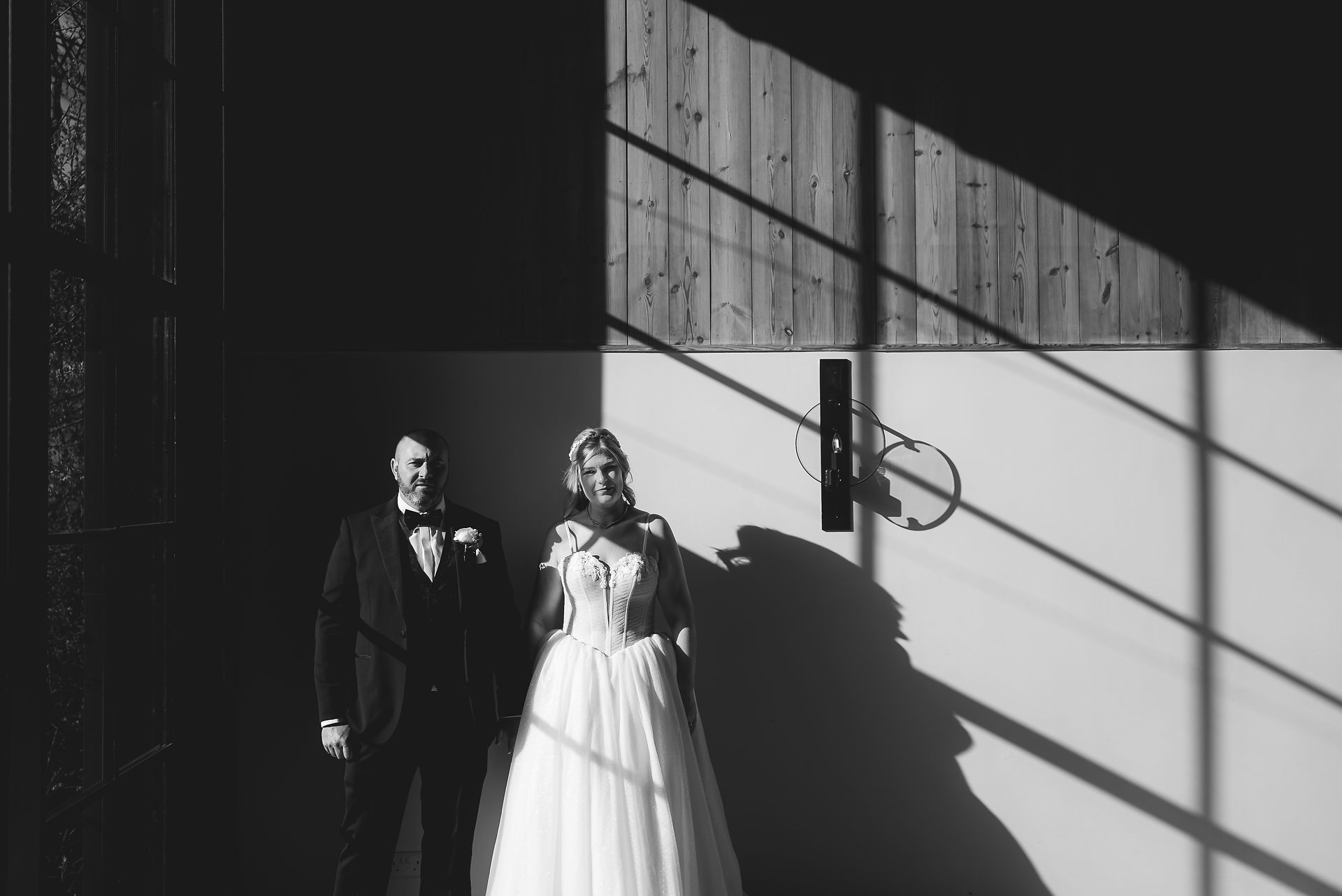 editorial photography bride and groom in large window at uk barn wedding venue