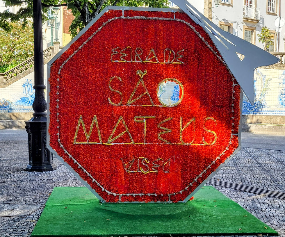 Large, red, octagonal-shaped sign with the words “Feira de São Mateus, Viseu”