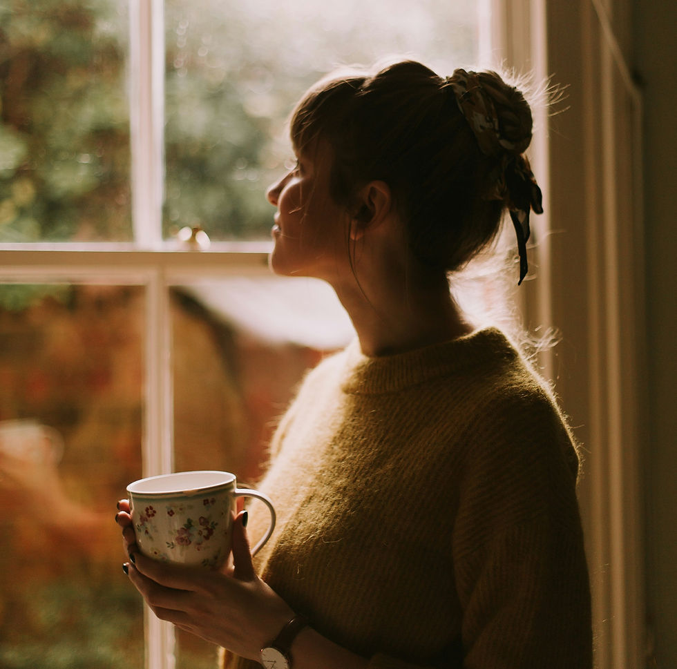 A Woman watching by window, thinking about her grief and finding meaning