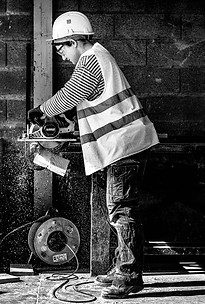 FEMME SCIANT DU BOIS SUR UN CHANTIER NB PAR SEBASTIEN DI SIVLESTRO