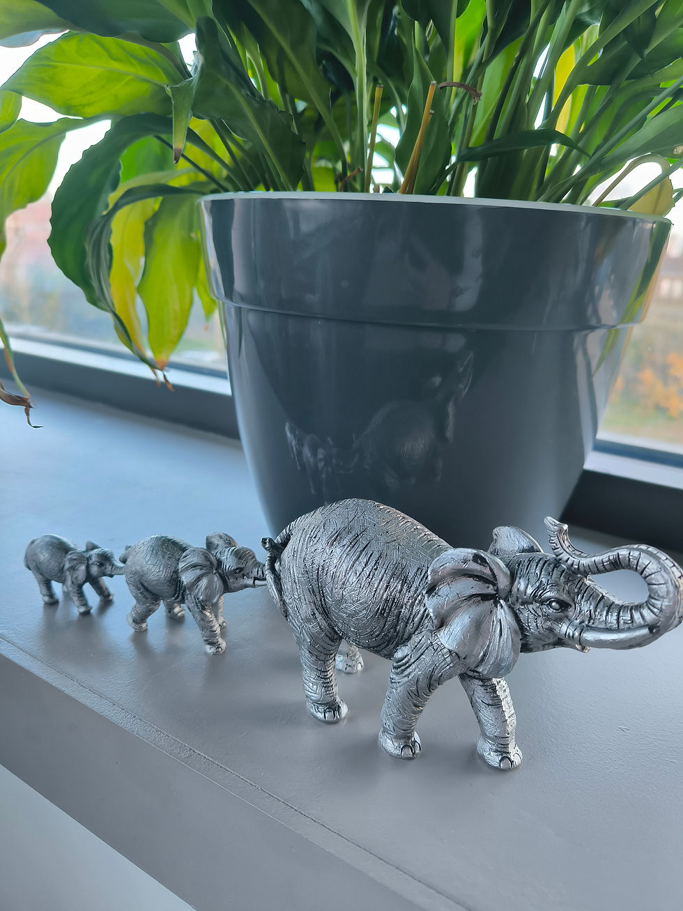 Détail éléphants gris en file indienne trompe accrochée queue famille déco modulable
