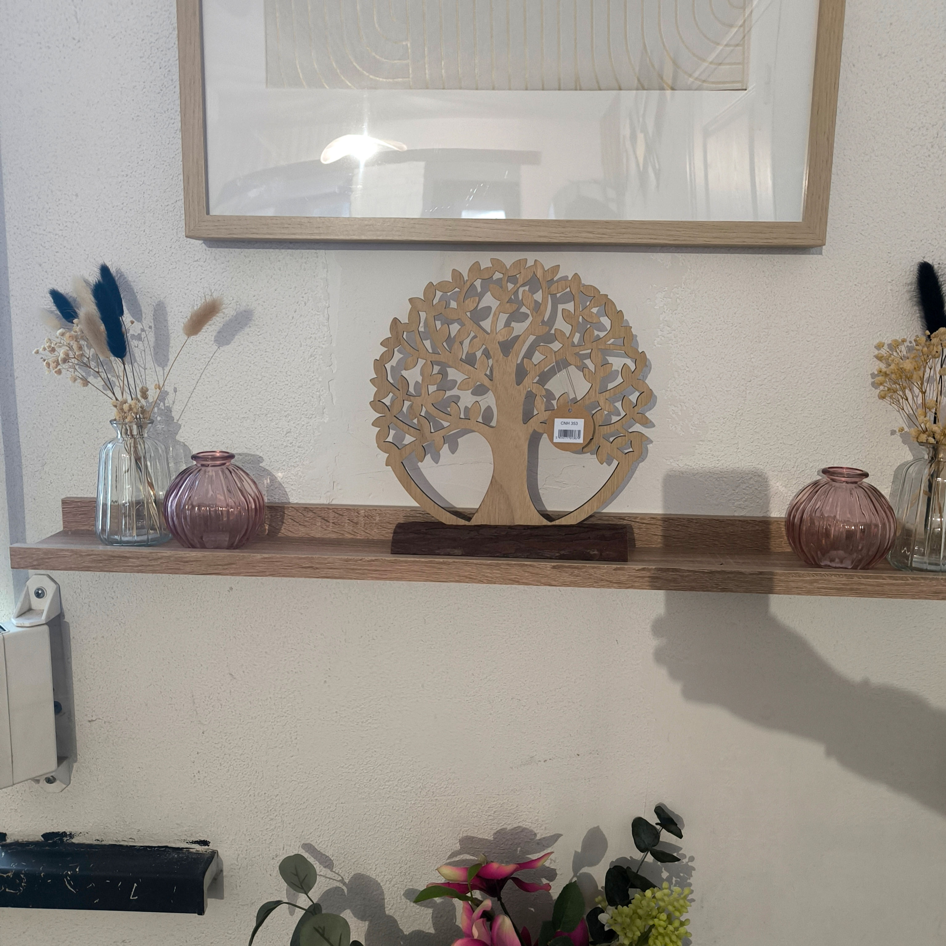 Arbre de vie décoratif posé sur une bûche dans un décor.